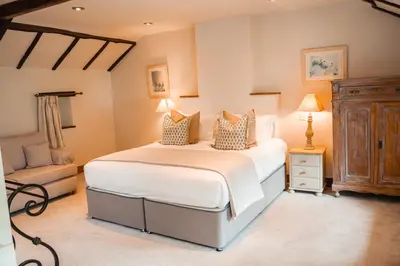 a bedroom with a large white bed and a chair at Riverside Country House and Cottage in Sunderland