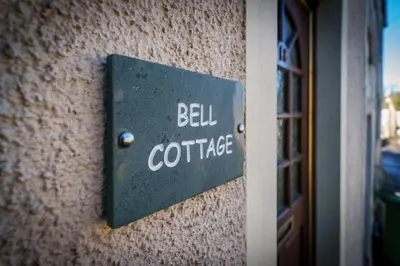 a sign on a building that says bell confidence at Bell Cottage - Cockermouth is five minutes walk to pubs, restaurants and shops in Cockermouth