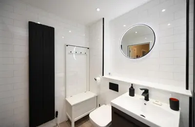 a white bathroom with a sink and a mirror at Barassie Bay View apartment in Troon