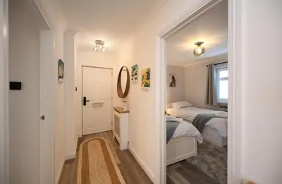 a small bedroom with two beds and a mirror at Barassie Bay View apartment in Troon