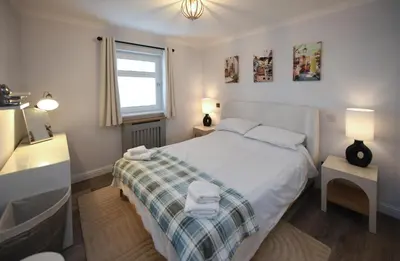 a bedroom with a bed and a sink and a window at Barassie Bay View apartment in Troon