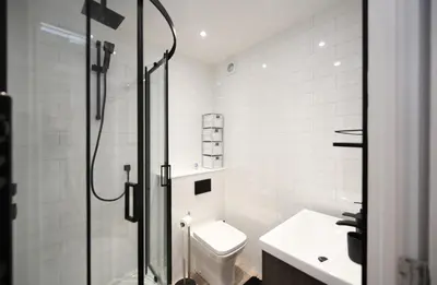 a white bathroom with a toilet and a shower at Barassie Bay View apartment in Troon