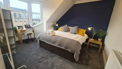 a bedroom with a bed with yellow pillows and a desk at 5 Bedrooms Sleeps 10 Full Kitchen Parking in Ayr