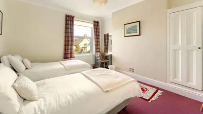 a bedroom with two beds and a window at Stanley House in Bassenthwaite