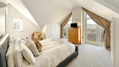 a bedroom with a large bed and a balcony at Skiddaw Heights in Keswick