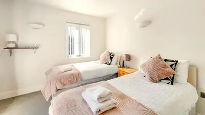 a bedroom with two beds with pink and white sheets at Skiddaw Heights in Keswick