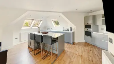 a kitchen with white cabinets and a kitchen island at Skiddaw Heights in Keswick