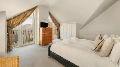 a bedroom with a large bed and a window at Skiddaw Heights in Keswick