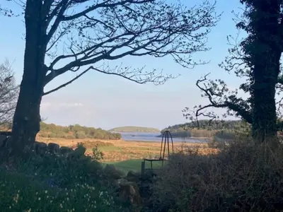 a park with a playground next to a lake at Gardeners Cottage in Auchencairn