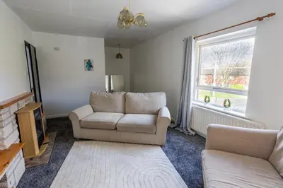 a living room with a couch and a chair and a window at Charming 2br Maisonette In Carlisle Center in Carlisle