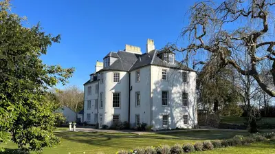 a large white house with a black roof at Underwood House Garden Flat in Kilmarnock