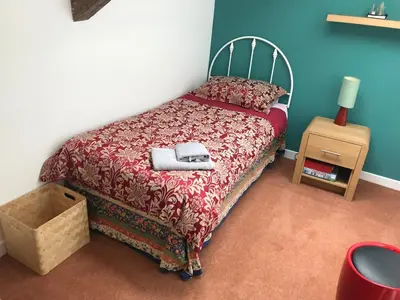 a bedroom with a bed with a red comforter at Harbour view retreat in Isle of Whithorn