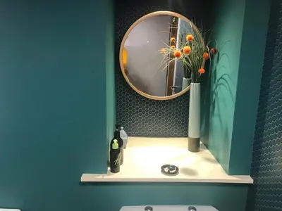 a bathroom with a mirror and a vase with flowers on a shelf at Harbour view retreat in Isle of Whithorn