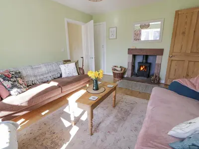 a living room with a couch and a fireplace at Morton Mains Steading Cottage in Thornhill