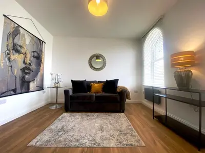 a living room with a couch and a mirror at 8 Clifton Terrace in Douglas