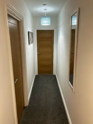 an empty hallway with a wooden door and a hallwayngth at 8 Clifton Terrace in Douglas