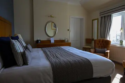 a hotel room with a large bed and a mirror at Highgrove House Hotel in Loans