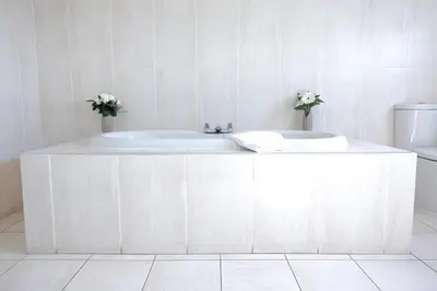 a white bathroom with a tub and a toilet at Highgrove House Hotel in Loans