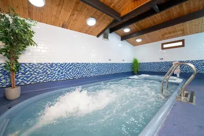 a jacuzzi tub in a room with blue and white tiles at Seabreeze Retreat in Port Carlisle