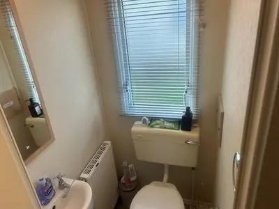 a bathroom with a toilet and a sink and a mirror at Seabreeze Retreat in Port Carlisle
