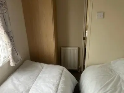 a bedroom with a white bed and a window at Seabreeze Retreat in Port Carlisle