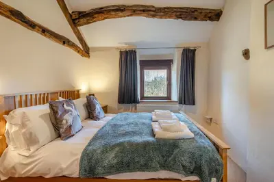 a bedroom with a large bed with a blue blanket at 3 Bed in Waberthwaite oc-d31079 in Waberthwaite