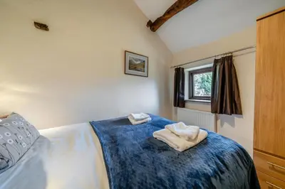 a bedroom with a bed with two towels on it at 3 Bed in Waberthwaite oc-d31079 in Waberthwaite