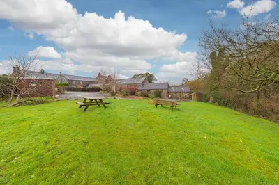 a park with two picnic tables in the grass at 3 Bed in Waberthwaite oc-d31079 in Waberthwaite