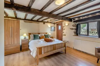 a bedroom with a bed with a dog laying on it at 3 Bed in Waberthwaite oc-d31079 in Waberthwaite