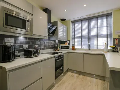 a kitchen with white cabinets and a stove top oven at The Lamphouse in Stranraer