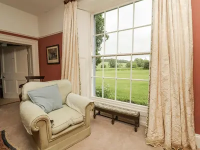 a living room with a chair and a large window at Westward Park in Wigton