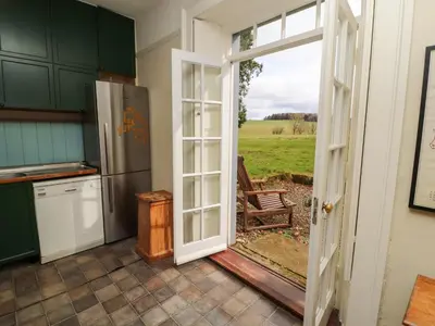 a kitchen with a door open to a yard at Westward Park in Wigton
