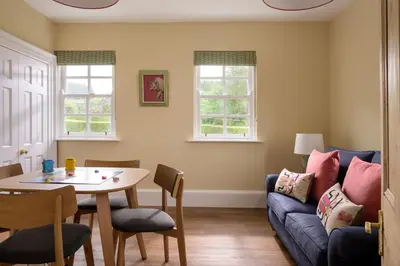 a living room with a blue couch and a table at Auchengashell in Kirkcudbright
