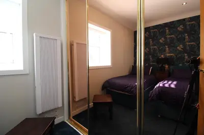 a room with a mirror and a bed at Links Cottage, Prestwick in Prestwick
