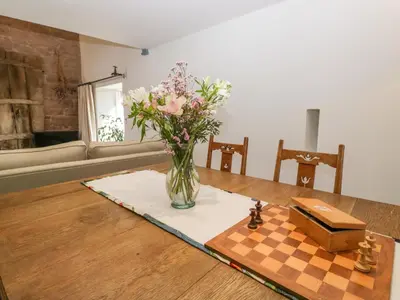 a vase of flowers on a table with a chessboard at The Roost in Carlisle