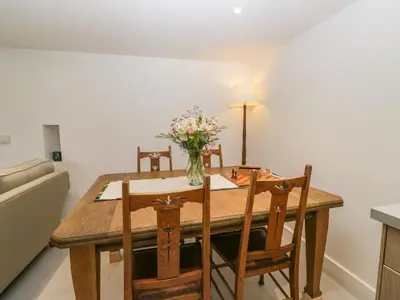 a dining room table with a vase of flowers on it at The Roost in Carlisle