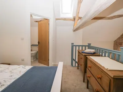 a bedroom with a bed and a wooden dresser at The Roost in Carlisle