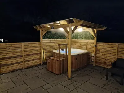 a wooden gazebo with a hot tub in it at Orchard Cottage At Gretna in Gretna