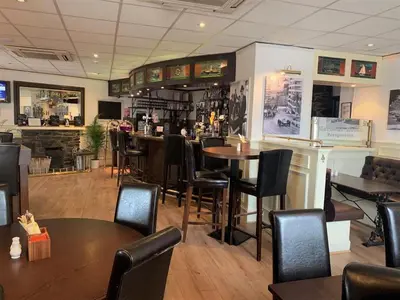 a restaurant with tables and chairs and a bar at The Harbour House Sea Front Hotel in Portpatrick