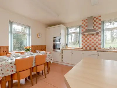 a kitchen with a table and chairs in a room at Holiday Home Doonans Cottage by Interhome in Straiton