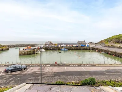 a car parked in a parking lot next to a harbor at Holiday Home The Knowe by Interhome in Portpatrick