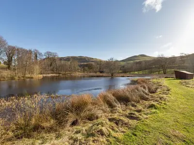 a view of a river with hills in the background at Holiday Home Foxglove cottage by Interhome in Straiton