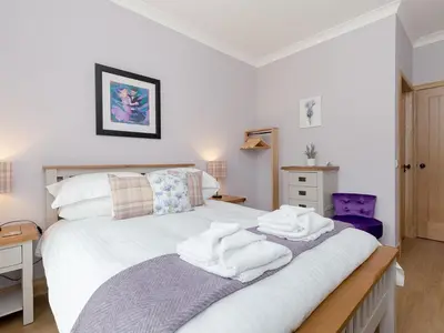 a bedroom with a bed with towels on it at Holiday Home Balbeg Cottage by Interhome in Straiton