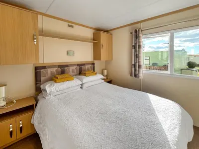 a bedroom with a large white bed and a window at The Haven in Cockermouth