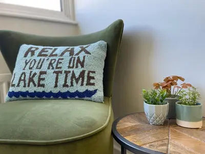 a pillow that says relax youre in take time at Fern Cottage in Portinscale