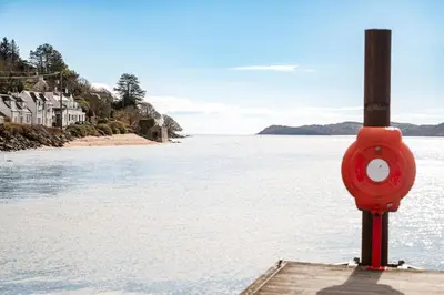 a red object sitting on the shore of a body of water at Ravens Craig in Kippford