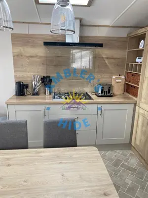 a kitchen with a counter with writing on the wall at Amblers Hide, Brigham, Cockermouth, Cumbria in Cockermouth