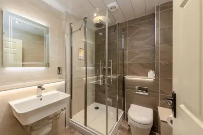 a bathroom with a shower and a sink and a toilet at Raise View House in Ambleside