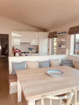 a kitchen with a wooden table and a dining room at The Moorings in Girthon