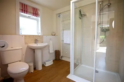 a bathroom with a shower and a toilet and a sink at Threaby Cottage in Girthon